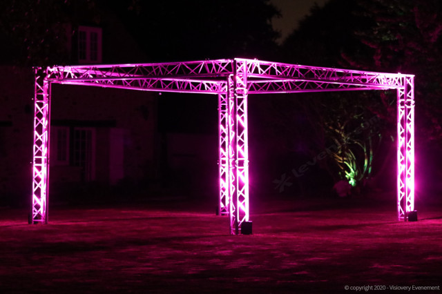 Mise en situation d'une structure alu éclairé en rose par projecteurs changeurs de couleurs